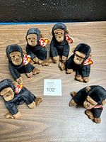 Photo showing six TY Original Beanie Baby Congo plush gorillas arranged on a wooden surface with TY heart-shaped tags visible.