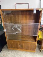 Full front view of the wooden display cabinet showing sliding glass doors and lower cabinet