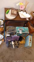 Overview of grooming tools and bathroom decor on carpet, showing hair clipper, hair dryers, boxes, ceramic dish, mirror and flowers.
