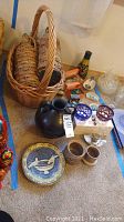 Overview of travel souvenirs, wicker basket, ceramics and glassware on carpet