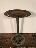 Full view of the cast iron birdbath showing circular basin and pedestal base.