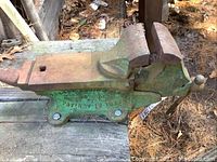 Full side view of bench vise on work surface showing overall shape and size