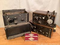 All three radios grouped with headset and boxed tube on tabletop