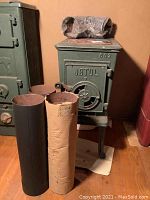 Overview showing Jotul stove with three straight pipe sections wrapped and one unwrapped at front