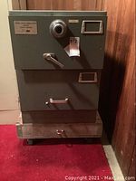 Full front view of the gray Mosler security safe showing two drawers, combination dial, and handles.