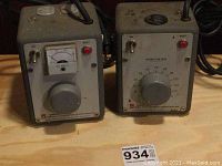 Photo showing two General Radio Variac autotransformers side by side on a wooden surface with visible cords, meters, knobs, and switches.