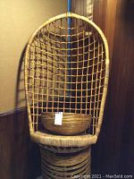 Hanging chair with bamboo woven seat and netted bamboo back, large bamboo bowl resting on the seat