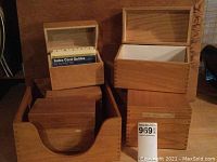Six vintage wooden file card and paper storage boxes displayed on a wooden surface against a wooden backdrop. Boxes have natural wood finish with dovetail joints and clear hinged lids.