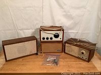 Four KLH units on wooden surface: two receivers and two speakers