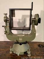 Front view of the Wild Heerbrugg camera mount showing the rectangular metal frame and knobs on each side for adjustments.