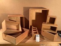 Group photo of all 8 unfinished wood bins showing different sizes and shapes arranged on a wood surface against a brown backdrop.