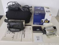 Overview of two Sony camcorders with box, camera bag, manuals, AC adapter and docking station