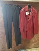 Photo showing the full set of Danier leather black pants and cherry red leather blazer hanging side by side.