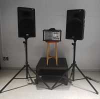 Lot overview showing two speakers on stands flanking the equalizer on a stool and table