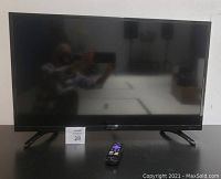 Front view of Sharp Roku 32 inch TV with remote placed in front.