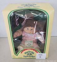 Front view of original box with doll inside and clear window showing doll dressed in pink gingham outfit.