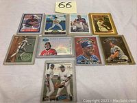 Group of 9 baseball cards displayed on white surface, variety of players, teams, some in card protectors