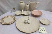 Overview of all vases, pitcher, plates, serving dishes, and bird figurines displayed on table