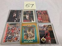 Image showing six Michael Jordan basketball trading cards from 1980s-1990s in protective sleeves.