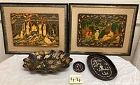 Full view of two framed Oriental folk portrait lacquer artworks and three decorative lacquer trays in front