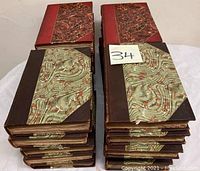 Two stacks of hardcover books with marbled and leather bindings, likely part of a historical book collection.
