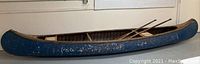 Side profile of the full canoe showing blue exterior paint and overall shape