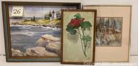 Three framed watercolor paintings displayed side by side: coastal seascape, floral study, and portrait.