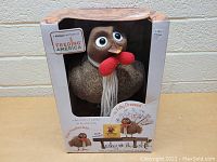 Front view of the stuffed turkey in its original box with visible brand name and Feeding America partnership badge.