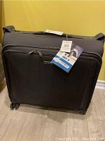 Full front view of black Samsonite Silhouette XV luggage with attached tags.