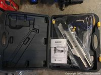 Mastercraft air powered nail framer inside black plastic carrying case with manual visible.