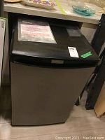 Full front view of the Danby bar fridge showing stainless steel door and black top.