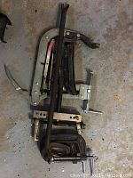 Photo showing various clamps including large C-clamp, pipe wrench clamp, and locking plier clamps.