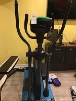 Elliptical trainer front view showing steerable handlebars and display console.