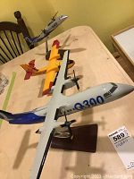 Photo showing all three plane models on a table, including the Bombardier Q300, Q400, and the yellow/red waterbomber plane