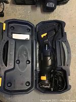 Mastercraft reciprocating saw inside blue plastic carrying case showing saw handle, blade clamp area, and power cord coiled.