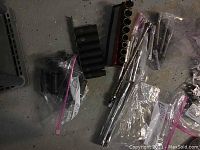 Assorted sockets in red holder and in plastic bags, some loose extension bars visible on floor