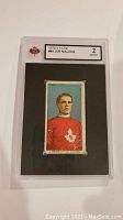 Full view of graded card in clear plastic case showing front of slab