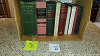 Box holding 11 antique medical books from 1901 to 1962 in varying condition with some cover damage noted.