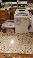 Black & Decker bread maker next to boxed Salton yogurt maker on kitchen counter.