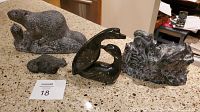 Overview of the full set of stone animal sculptures including beaver, chipmunks, otter and soapstone bird figures arranged on countertop