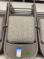 Stacked view of the folded chairs showing striped upholstery on seats and metal frames.