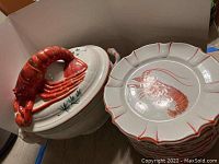 Overall view of lobster tureen and stacked lobster plates, showing design and quantity.