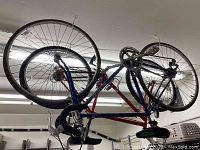 Photo of the whole Nishiki road bike hung from the ceiling showing frame, wheels, pedals, and handlebars.