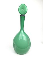 Front view of the green glass decanter showing oval stopper, slender neck, bulbous body with dimples.