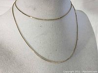 Necklace draped on fabric bust showing full length and drape