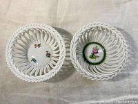 Top view of both white porcelain dishes showing open latticework and hand painted floral centers