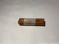 Photo of a paper coin roll labeled for 50 cents in pennies, containing unsearched wheat pennies from 1920.