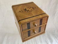 Front angled view showing chest of drawers and Scotty dog inlay on top.