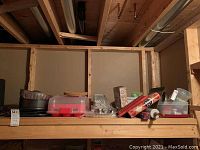 Shelf with assorted bakeware, food storage containers, and cookbooks.