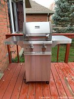Front view showing stainless steel hood, control knobs, Saber badges and side shelves